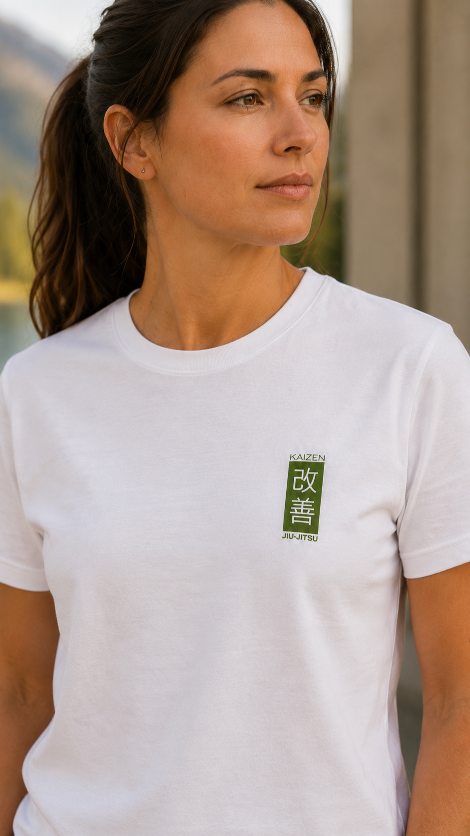 Frau im weissen Kaizen T-Shirt – Nahaufnahme des mossgrünen 改善 Brustlogos, Frontansicht
