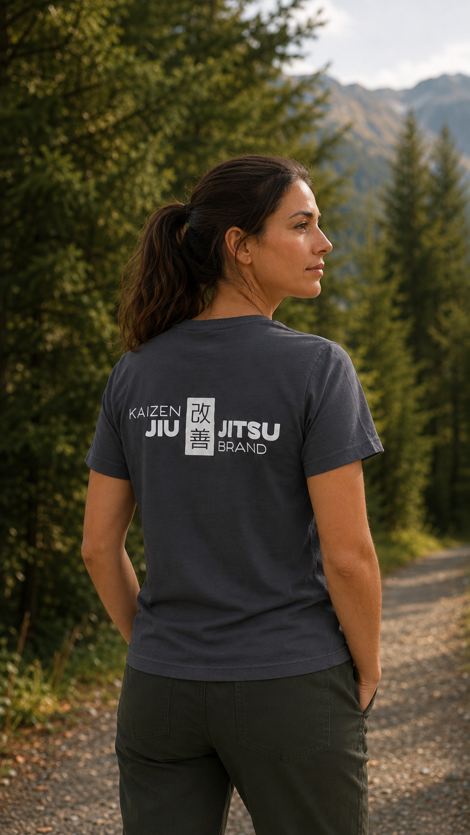 Frau im grauen Kaizen T-Shirt auf einem Bergweg – weisses 改善 Rückenlogo, Rückansicht